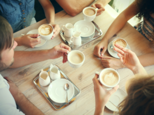 group of adults drinking coffee at table