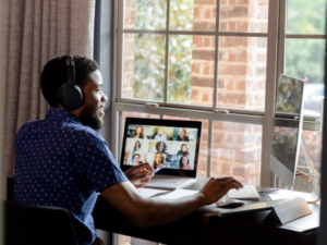 Person sitting at desk during online meeting on his laptop